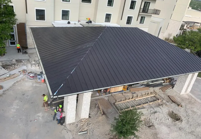 Metal roofing installation team working on a commercial building in North Miami Beach